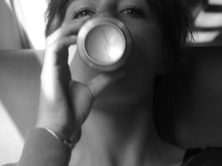 a woman taking a drink from a coffee mug