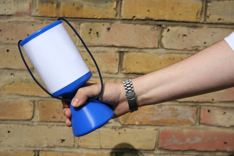 the hand holds an blue and white flashlight