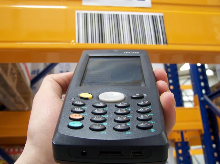 a person is holding a phone that has barcodes on it