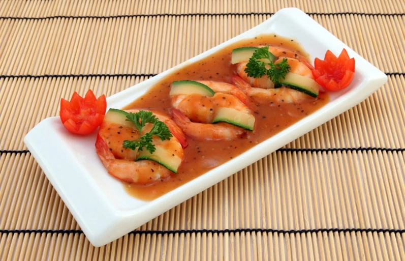 some shrimp is on some sauce with garnishes