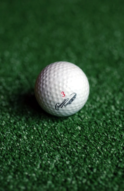 close up view of golf ball on green carpet