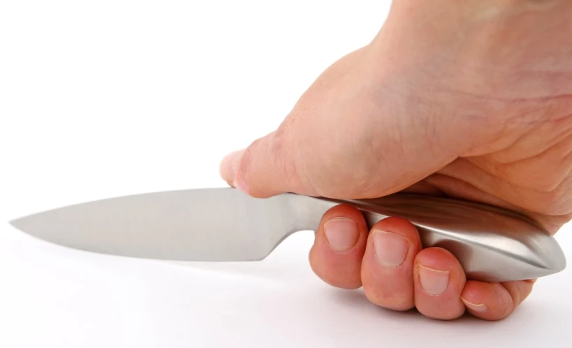 a hand holding a knife on a white background