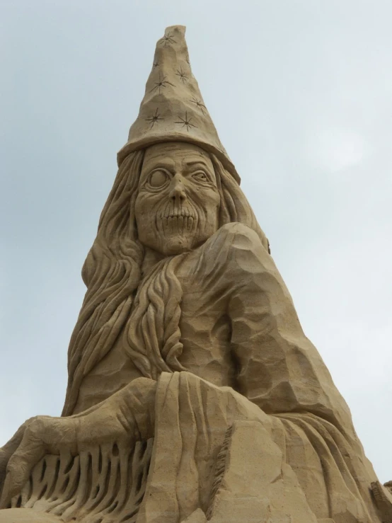 a sand sculpture with a very long beard and wearing a hat