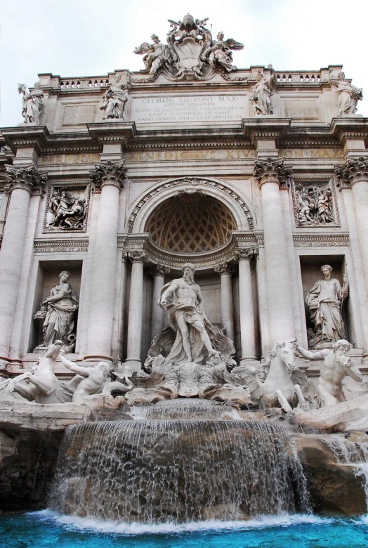 fountain in the middle of a building with a bunch of statues surrounding it