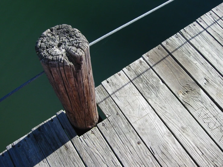 a wooden dock has a chain running from it