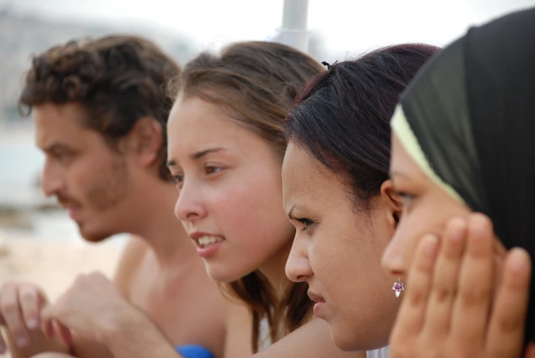 a group of people sit together on the beach