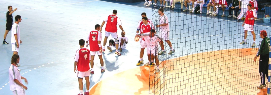 several people standing on the beach playing volleyball