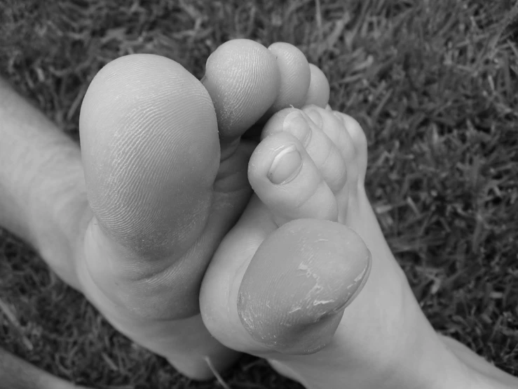 a person that is holding a baby's feet on the ground