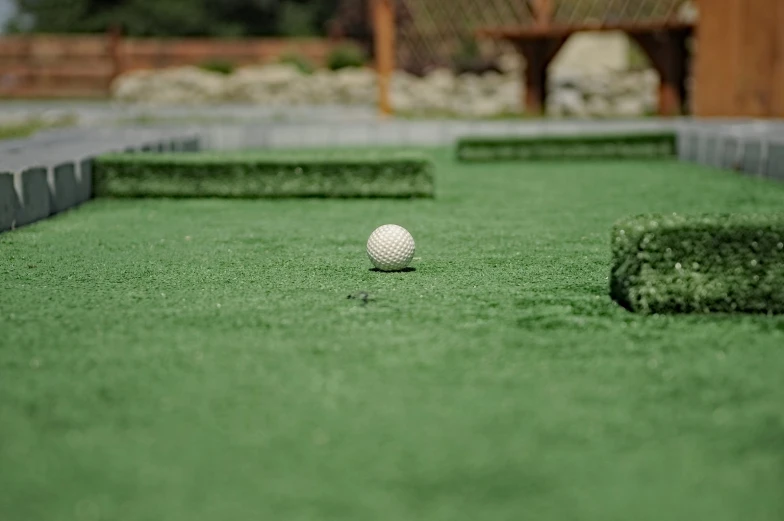 a ball is in the center of an artificial golf court