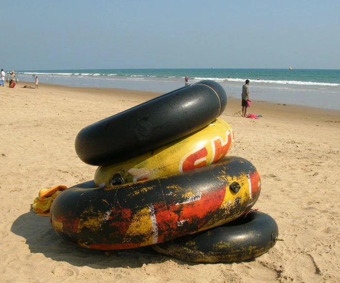 large inflatable buoys on a beach with people nearby