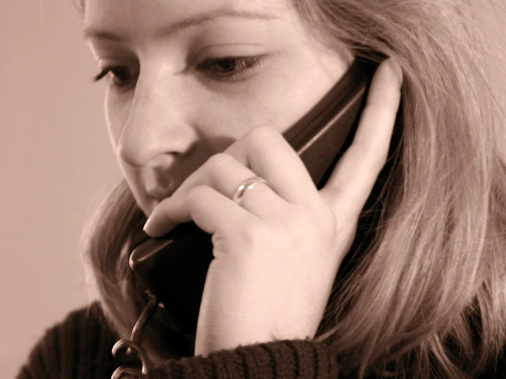 a woman in black shirt holding a cellphone to her ear