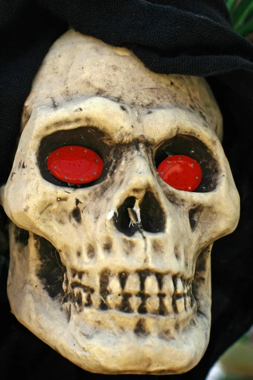 a human skull with red eyes and a hat