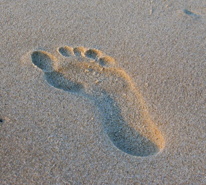 a footprints imprint in the sand on a beach