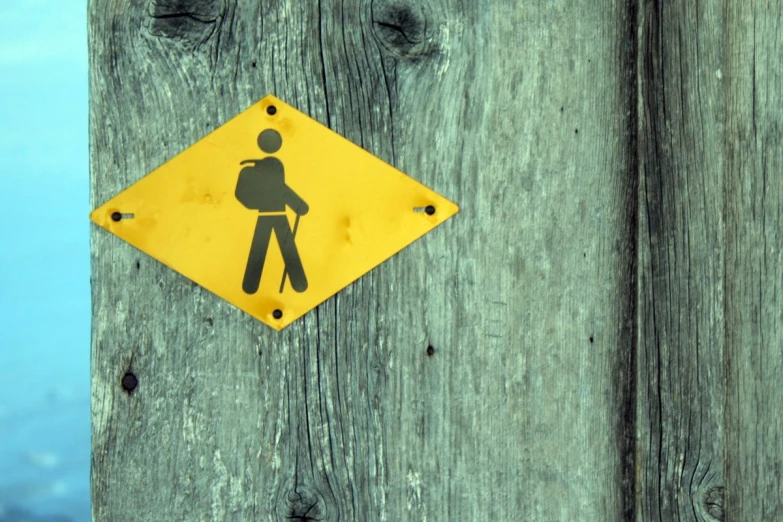 an image of a pedestrian sign hanging from the side of a pole