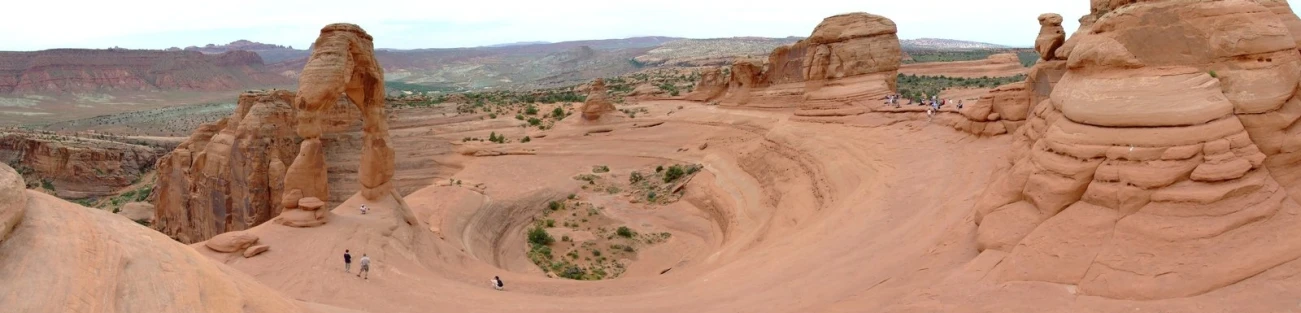 a group of people walking on top of some tall rocks