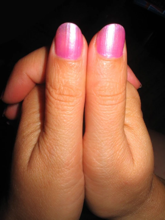a person with a pink manicure on their nails