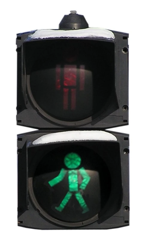 a traffic signal with a green pedestrian sign on it