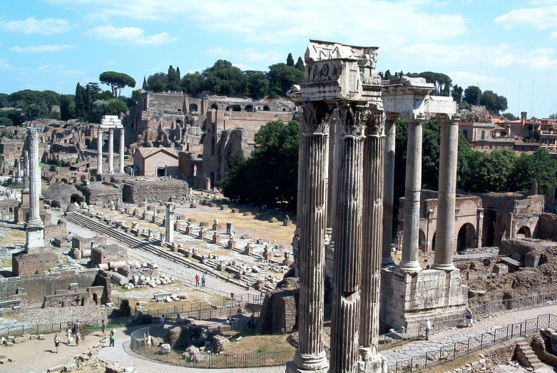 a roman ruins with large columns and trees