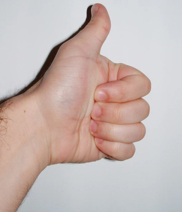 a person holding their thumb up making a thumbs up