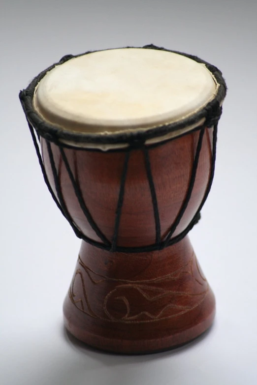 a brown drum with black strings and a wooden case