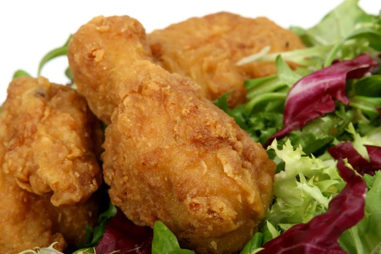 a plate with lettuce, greens and meat patties