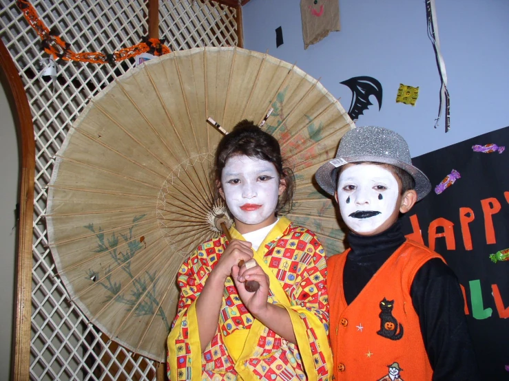 two children posing with painted faces on halloween costumes