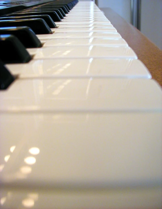 a black and white piano sits on top of a wooden table