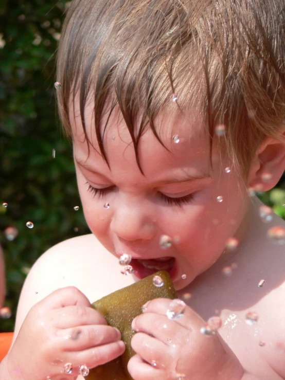 a small child biting into a piece of food