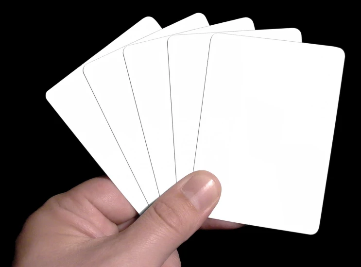 a hand holding four blank cards and touching it