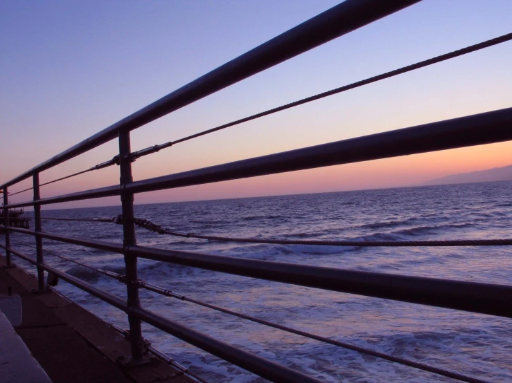 people standing on the edge of a beach boardwalk