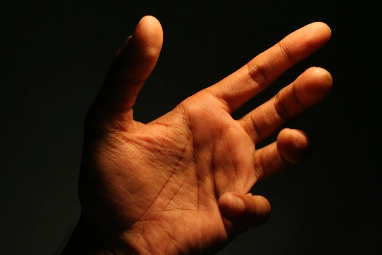 a hand reaches up and extends to catch an object in the air