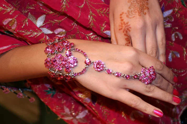 a close up of two woman's hands holding jewelry