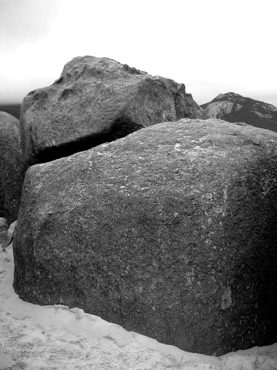 rocks in the sand with an ocean in the background