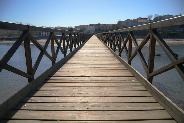 the wooden dock is attached to a large body of water