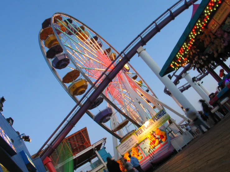 a ferris wheel and ride are shown against the blue sky