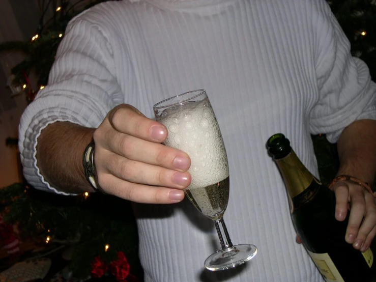 a person holding a champagne glass with bubbles in it