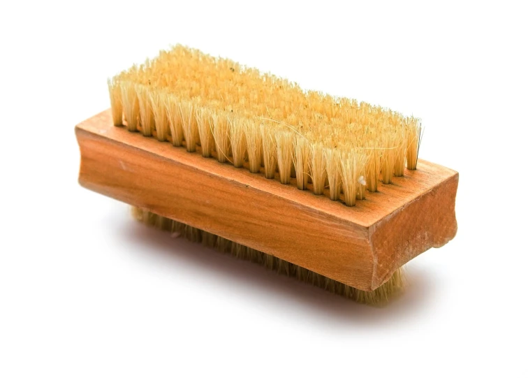 a wooden comb sitting on top of a white surface