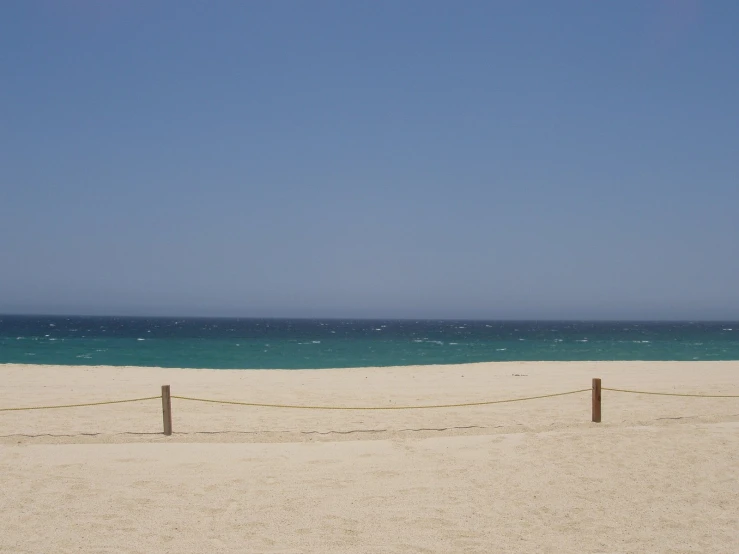 the white sandy beach is deserted as waves crash against the ocean