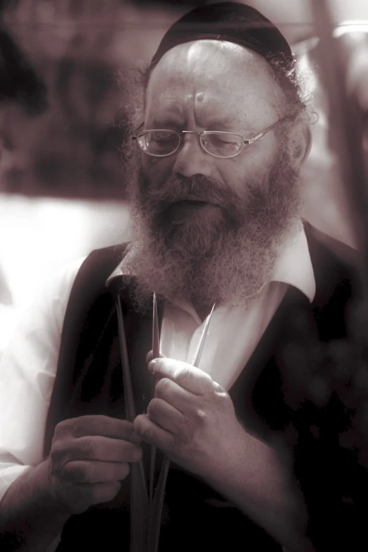 a bearded man with a large white beard and glasses holding soing