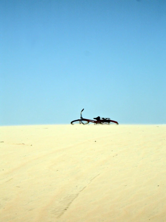 a airplane in the sky over sand dunes