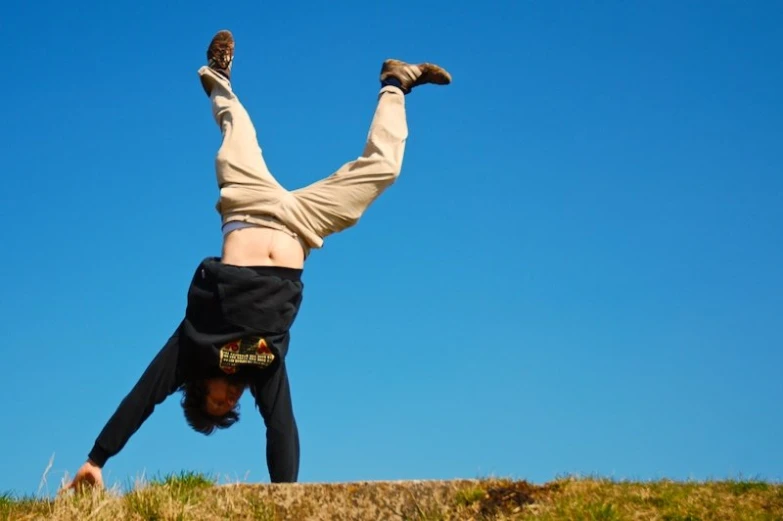 there is a man with his hands off the ground doing a hand stand