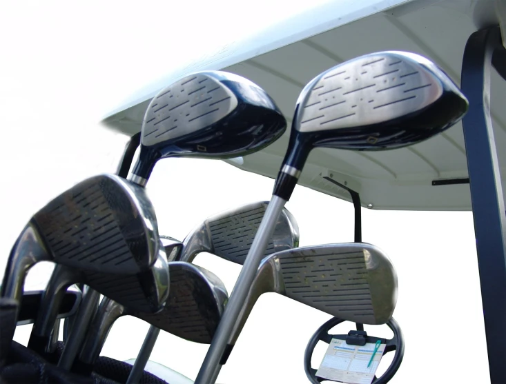 many different iron - based golf clubs are positioned for play