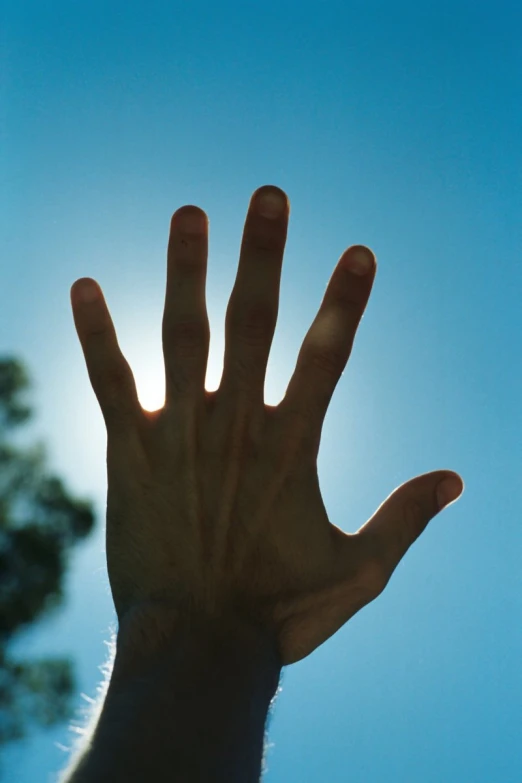 the view of someone's hand with their right hand up