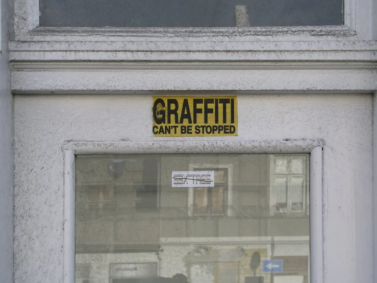 a sign on the side of a building stating that graffiti can be stopped
