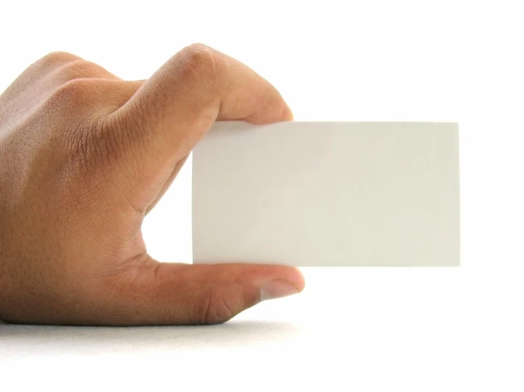 a hand holding up a small white business card