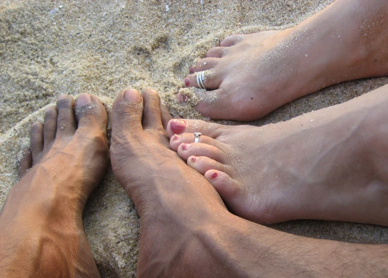 there are two people laying on a sandy beach