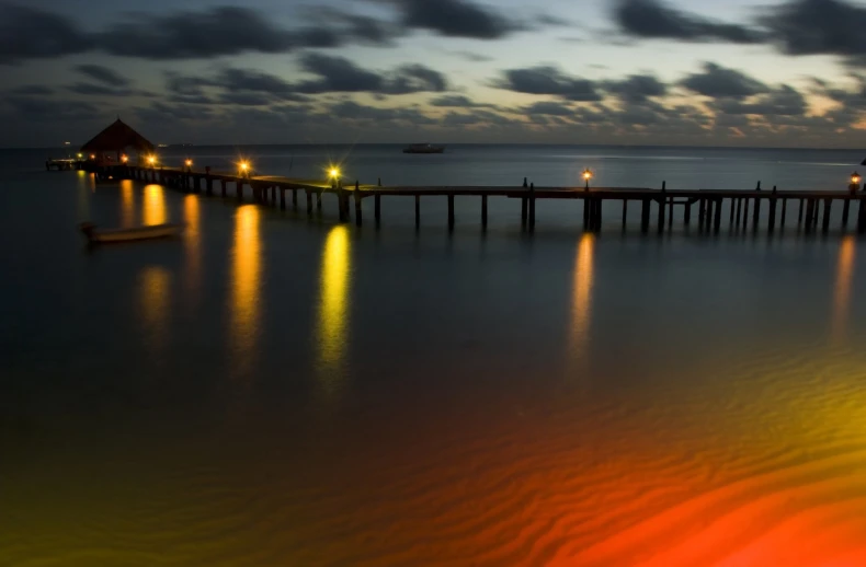 two piers in the water are lit up by night lights