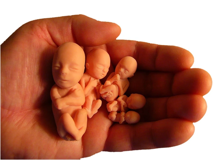 someone is holding up a small pair of tiny baby figurines