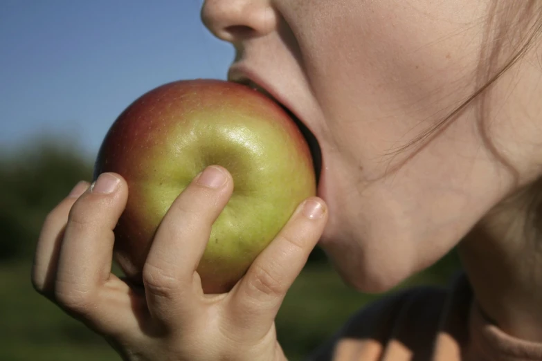 a close up of a person licking an apple