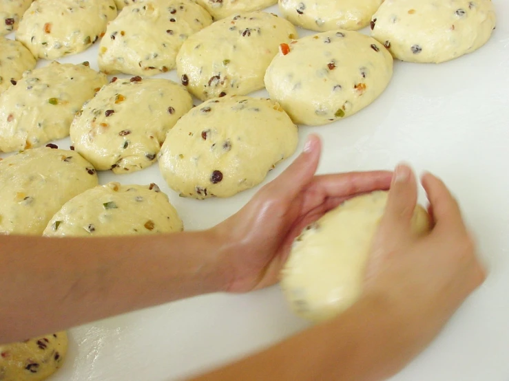 a person is peeling a cookie with the hand